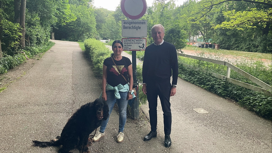 GR Astrid Sinkovits und GR René Hansy stehen mit einem Hund in einer Hundesicherungszone in Baden.